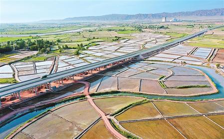 甘蒙高速公路與甘州區(qū)烏江鎮(zhèn)元豐村的稻田和蔬菜基地構成一幅美麗的畫卷