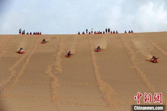 6月13日，敦煌鳴沙山月牙泉景區舉辦滑沙比賽。　張曉亮 攝