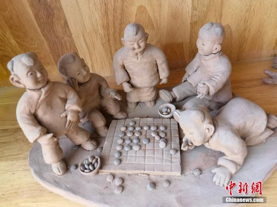 圖為泥塑作品展現(xiàn)下棋場(chǎng)景。 劉玉桃 攝