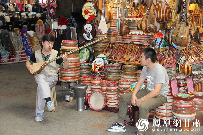 烏魯木齊二道橋巴扎內，店主正在向客人展示樂器。楊文遠 攝